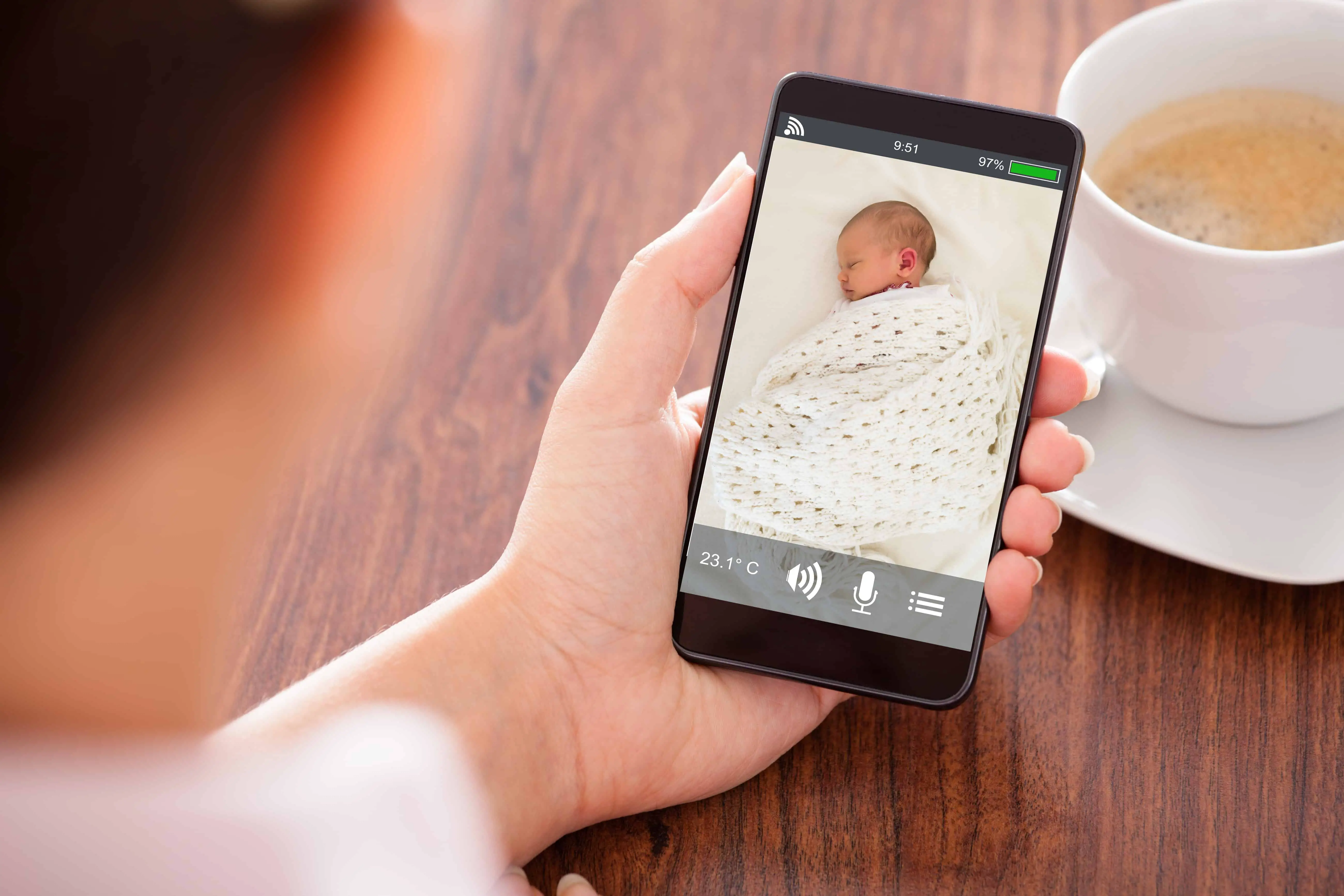 Person monitoring baby with phone app